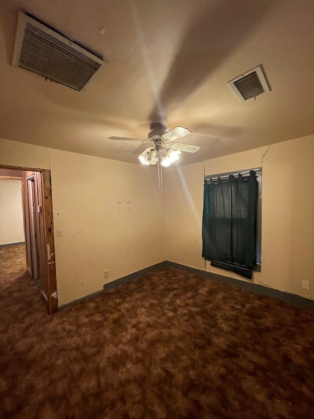 empty room with dark carpet and ceiling fan