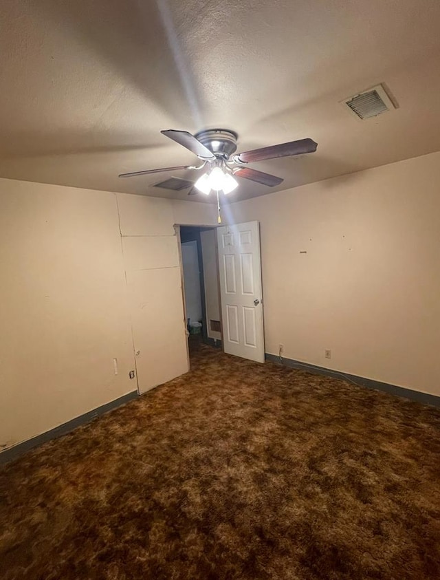 carpeted spare room with ceiling fan and a textured ceiling