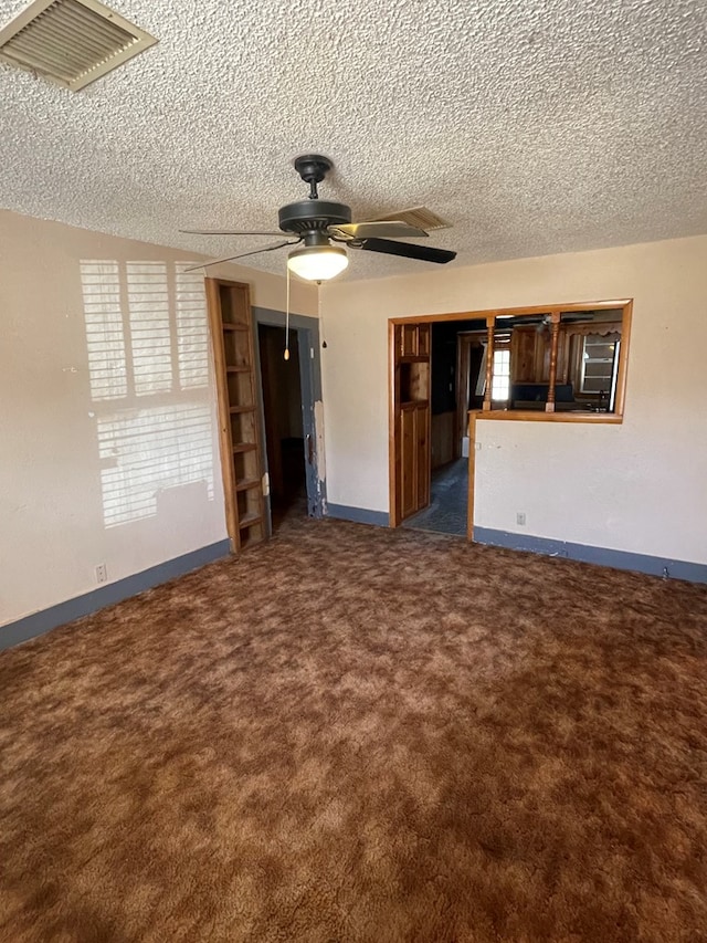 unfurnished living room featuring dark colored carpet, a textured ceiling, and ceiling fan