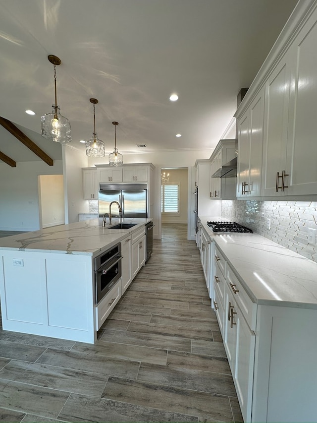 kitchen with stainless steel appliances, white cabinetry, decorative light fixtures, and light stone countertops