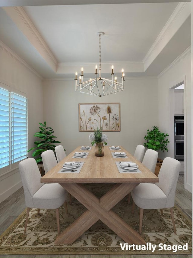 dining space featuring a tray ceiling, crown molding, and wood finished floors