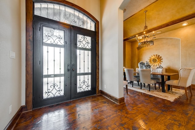 foyer with dark hardwood / wood-style flooring, french doors, and a chandelier