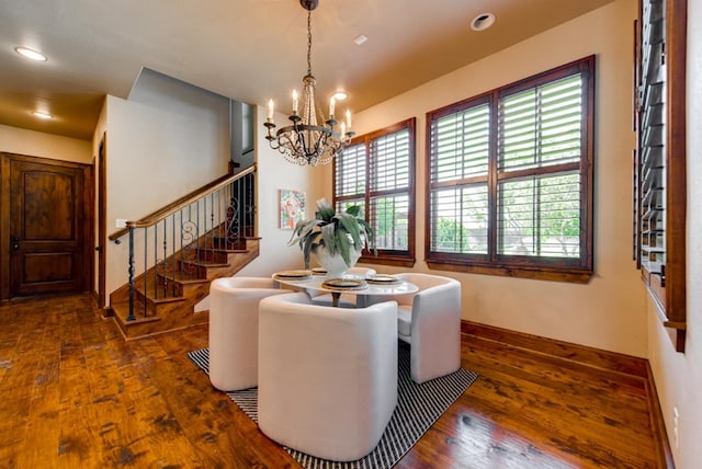 dining area with plenty of natural light, a notable chandelier, and dark hardwood / wood-style floors