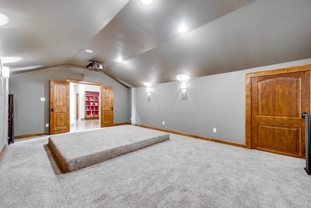 bonus room featuring lofted ceiling and light colored carpet