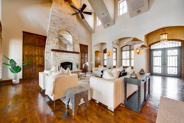 living room featuring ceiling fan, french doors, a towering ceiling, and plenty of natural light