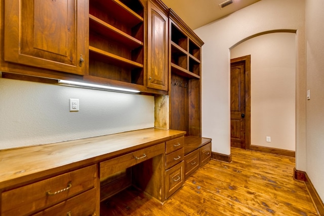 office space featuring built in desk and dark hardwood / wood-style floors