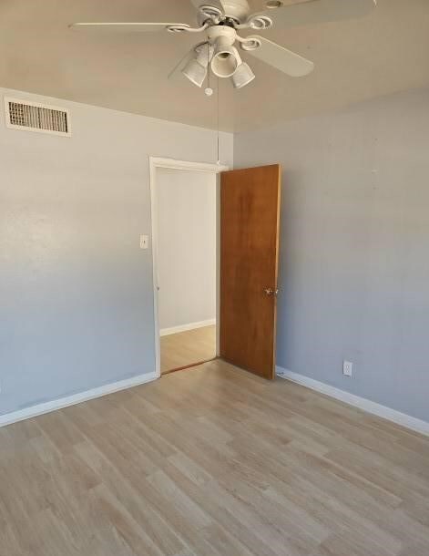 empty room featuring ceiling fan and light hardwood / wood-style floors