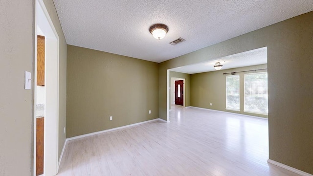 4203 Skyline Dr, Midland, TX 79707 - empty room featuring light wood-style flooring, a textured ceiling, and baseboards