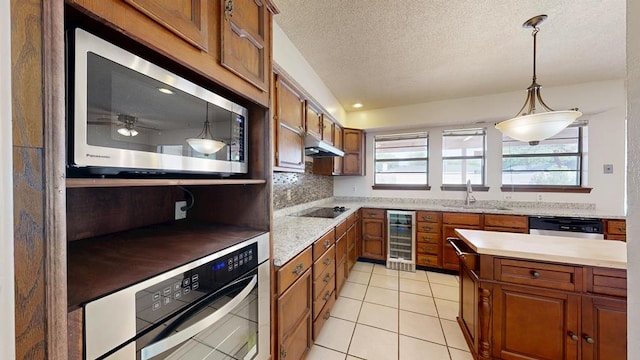 4203 Skyline Dr, Midland, TX 79707 - kitchen featuring appliances with stainless steel finishes, wine cooler, brown cabinets, a sink, and healthy amount of natural light