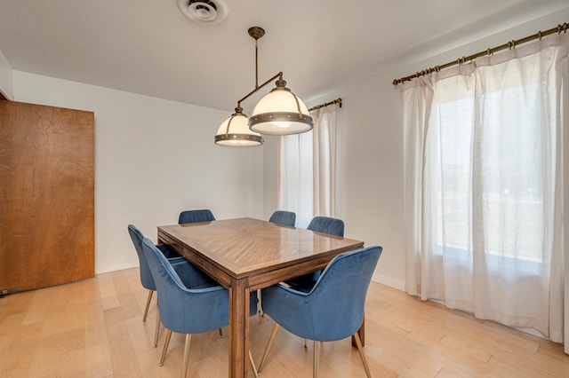 dining area with visible vents and light wood-type flooring