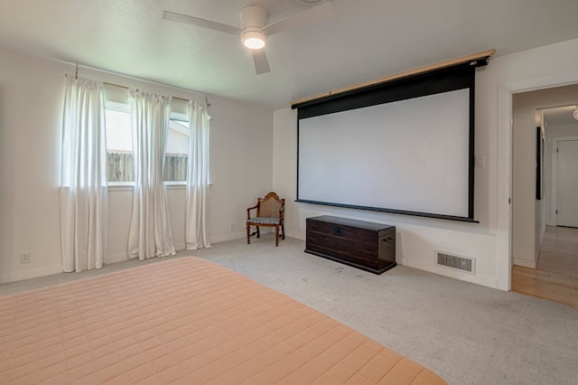 cinema room featuring baseboards, carpet, a ceiling fan, and visible vents