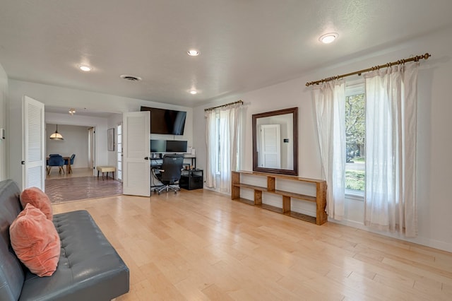 living area with baseboards, recessed lighting, light wood-style flooring, and visible vents