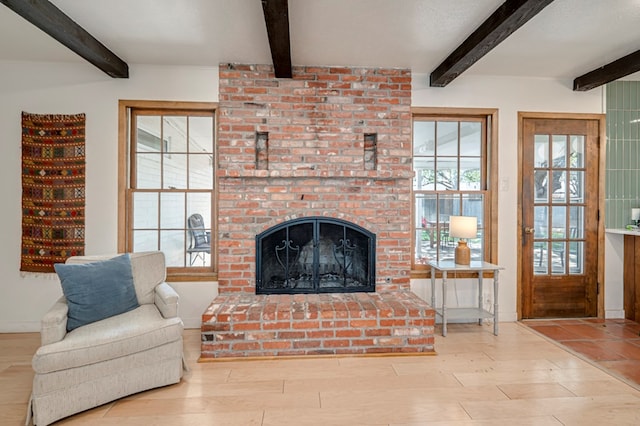 living room featuring a brick fireplace and beam ceiling