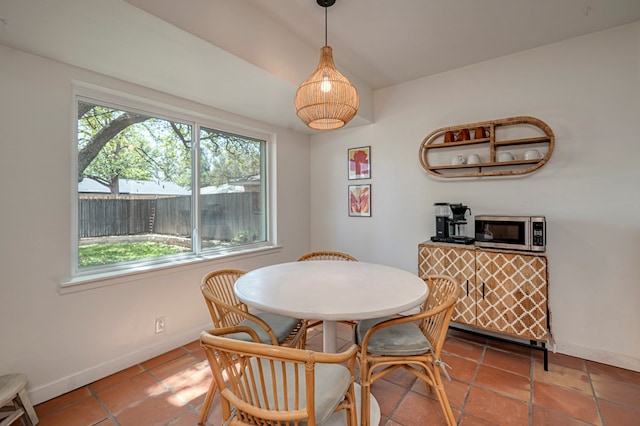 dining space with baseboards and tile patterned flooring