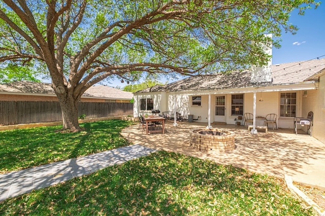 rear view of house featuring fence, a yard, an outdoor fire pit, and a patio area