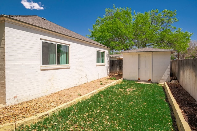 view of yard featuring a fenced backyard, an outbuilding, and a shed
