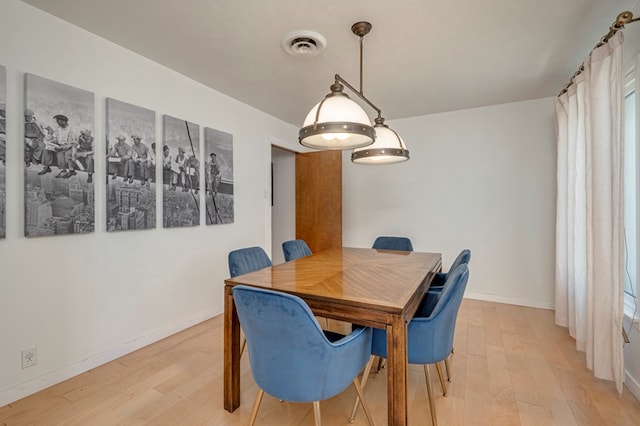 dining space featuring baseboards, light wood-style flooring, and visible vents