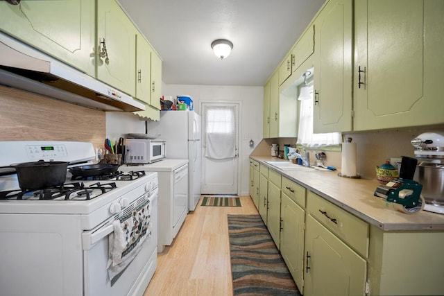 kitchen featuring light hardwood / wood-style floors, white appliances, sink, and green cabinetry