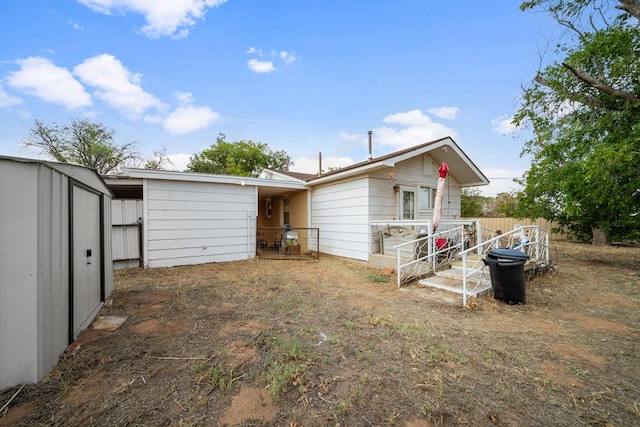 rear view of house with a storage unit