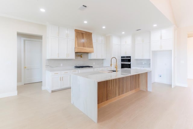 6407 W County Rd 41, Midland, TX 79707 - kitchen featuring premium range hood, gas stovetop, backsplash, a sink, and light wood-style floors