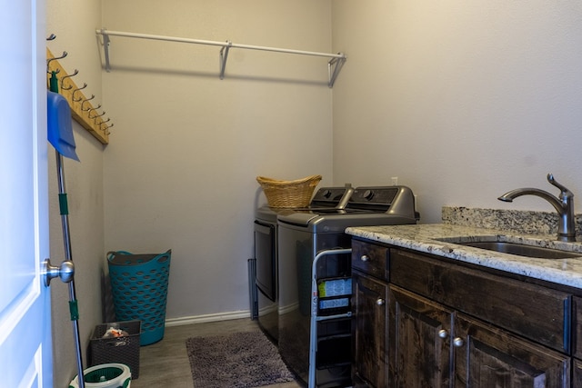 washroom with cabinets, hardwood / wood-style floors, separate washer and dryer, and sink