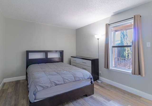 bedroom with a textured ceiling and hardwood / wood-style flooring