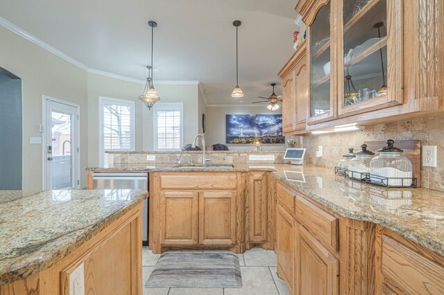1900 Fringewood Dr, Midland, TX 79707 - kitchen with light stone counters, decorative backsplash, stainless steel dishwasher, a sink, and ornamental molding