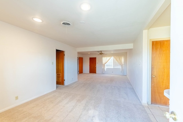 spare room featuring visible vents, baseboards, light colored carpet, and a ceiling fan