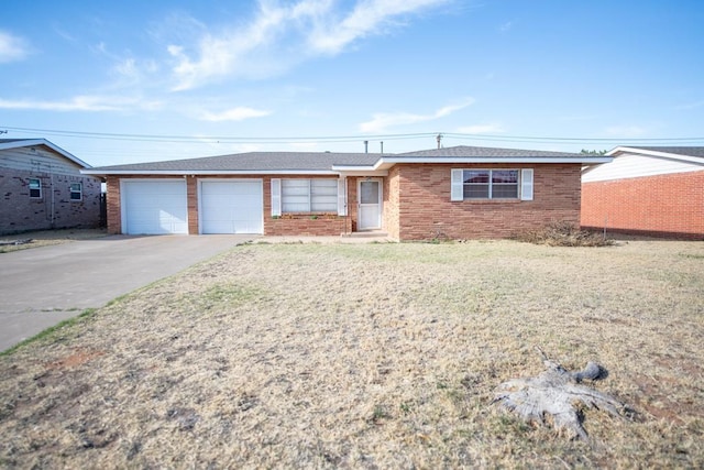 single story home with a garage, brick siding, concrete driveway, and a front yard