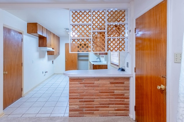 kitchen with a sink, light tile patterned flooring, and light countertops