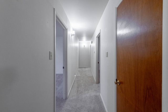 corridor featuring light carpet and baseboards