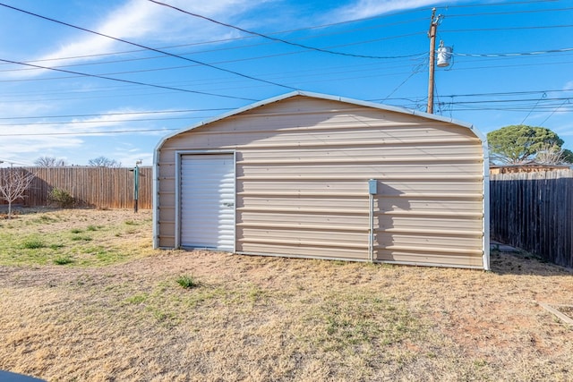 garage with a storage unit and fence