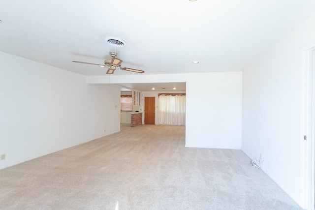 empty room with light colored carpet, visible vents, and ceiling fan