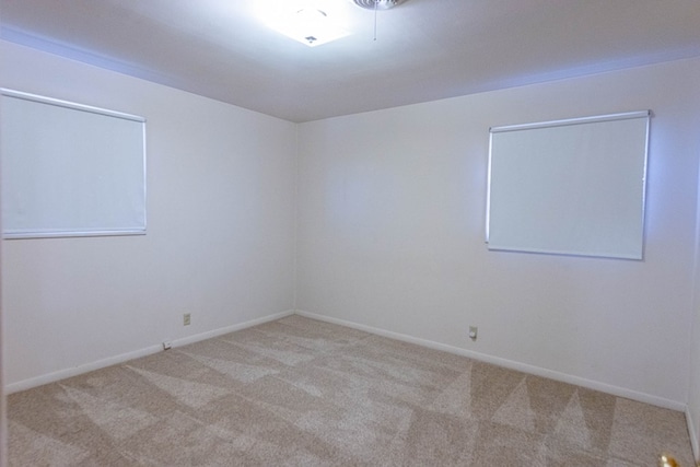 carpeted empty room featuring baseboards