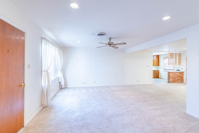 spare room with light colored carpet, recessed lighting, a healthy amount of sunlight, and visible vents