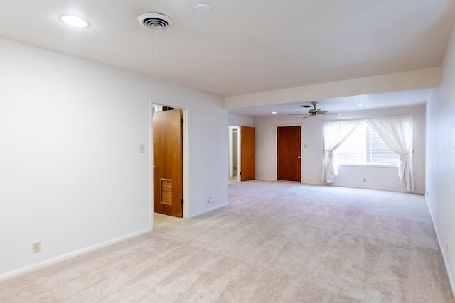 unfurnished room featuring visible vents, baseboards, light colored carpet, and ceiling fan