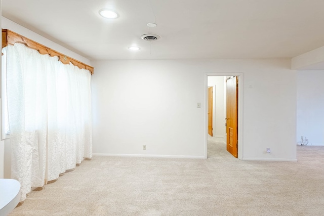 empty room with light carpet, visible vents, recessed lighting, and baseboards