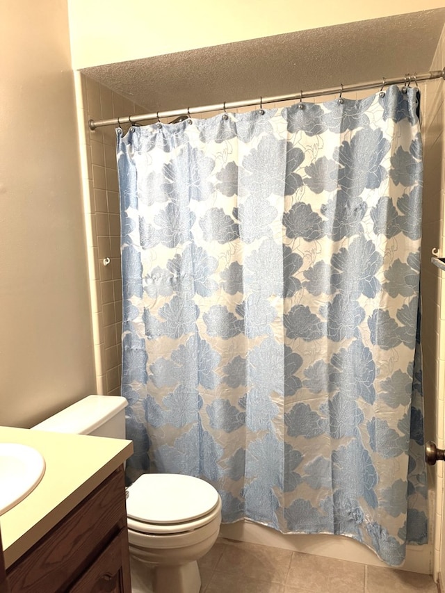 bathroom featuring tile patterned floors, toilet, curtained shower, a textured ceiling, and vanity