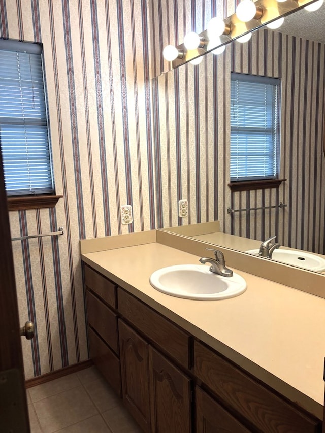 bathroom with tile patterned floors, vanity, and wallpapered walls