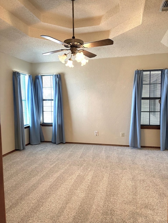 spare room with a textured ceiling, a textured wall, visible vents, and light carpet