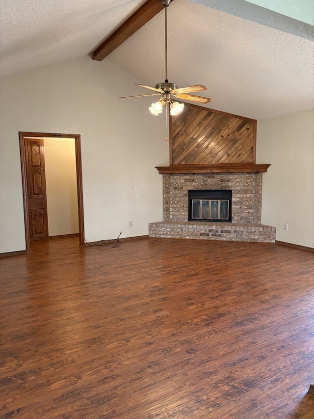 unfurnished living room featuring wood finished floors, a fireplace, ceiling fan, a textured ceiling, and beamed ceiling