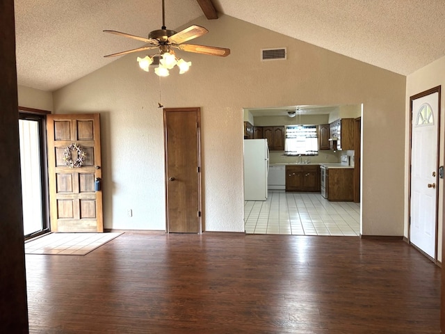 unfurnished living room with a textured ceiling, a ceiling fan, visible vents, and light wood-type flooring