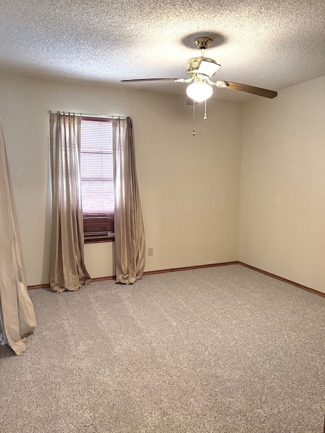 spare room with baseboards, light carpet, a textured ceiling, and ceiling fan