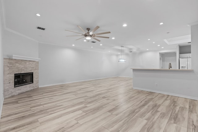 3502 Wedgewood St, Midland, TX 79707 - unfurnished living room featuring ceiling fan, a fireplace, recessed lighting, light wood finished floors, and crown molding