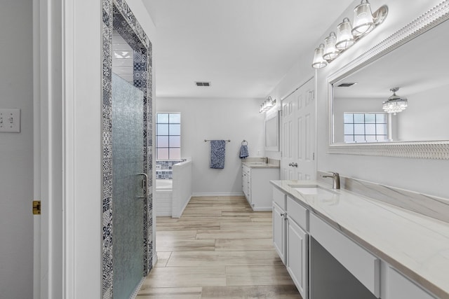 3502 Wedgewood St, Midland, TX 79707 - full bath featuring a chandelier, a stall shower, two vanities, and wood finished floors