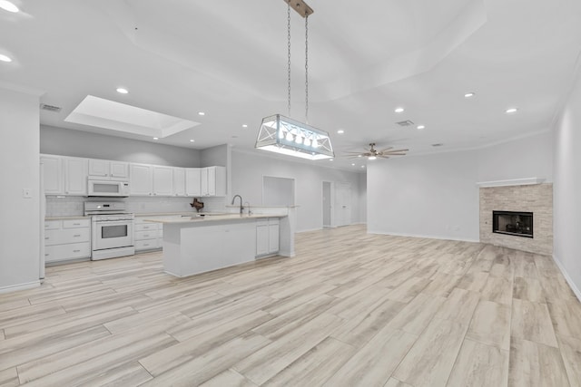 3502 Wedgewood St, Midland, TX 79707 - kitchen with white appliances, a skylight, open floor plan, light countertops, and white cabinetry