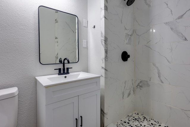 bathroom with vanity, a shower, and toilet