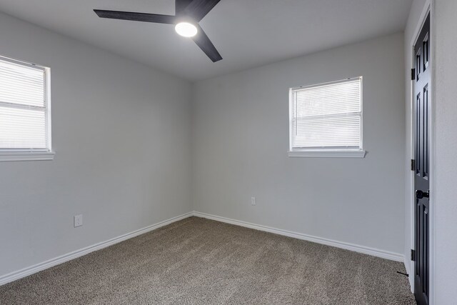 unfurnished room with carpet flooring, ceiling fan, and baseboards