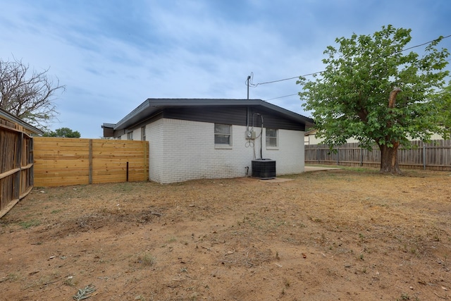 rear view of property with brick siding and a fenced backyard