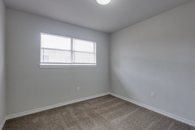 unfurnished room featuring carpet flooring and baseboards